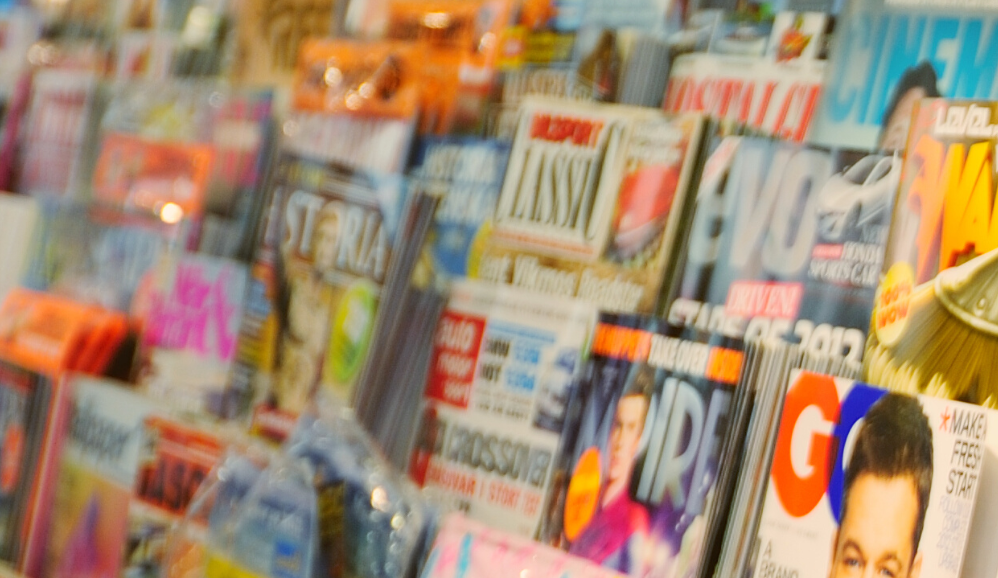 blurred image of magazines on a newsstand